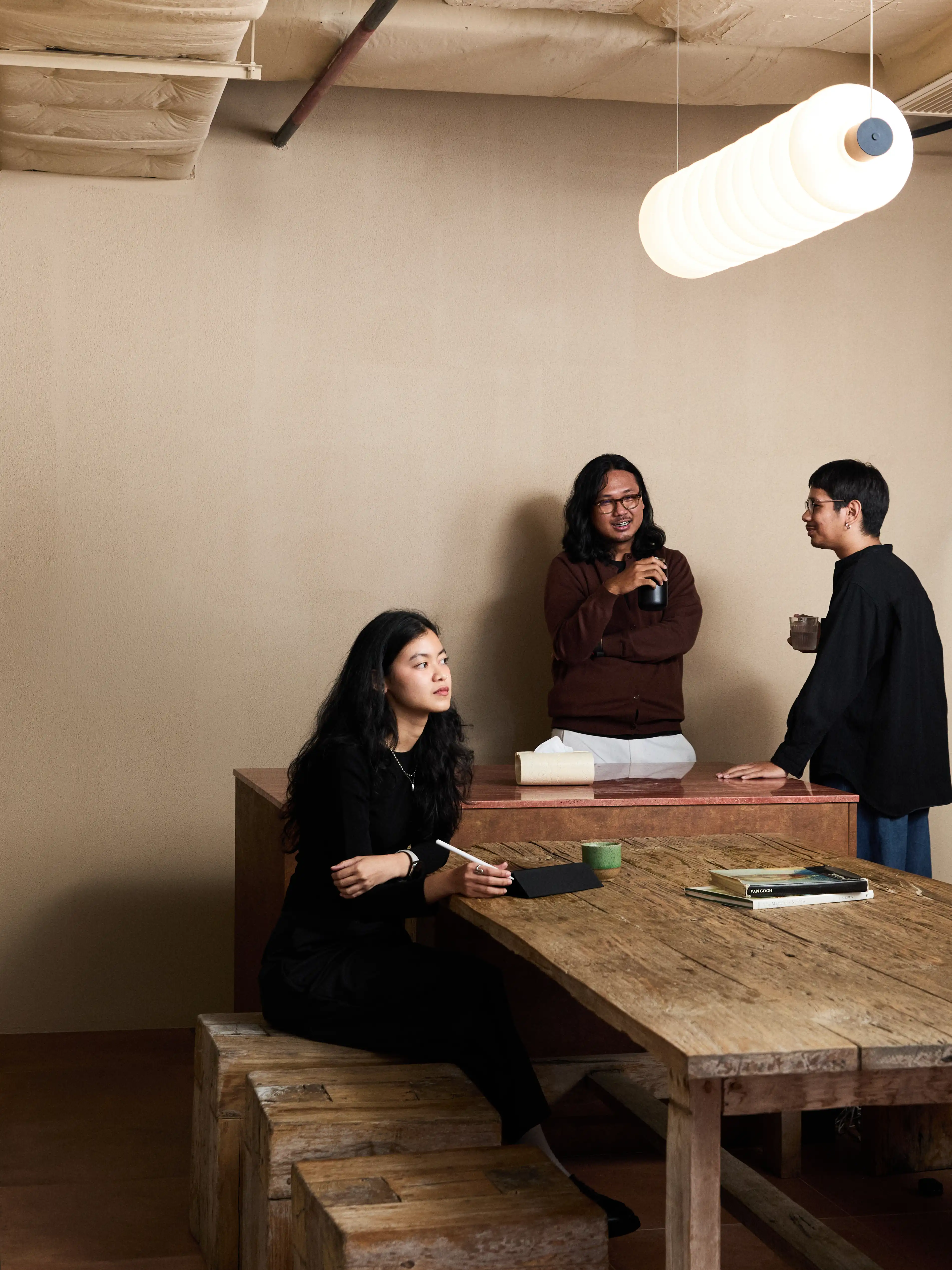 Designers discussing project around wooden table